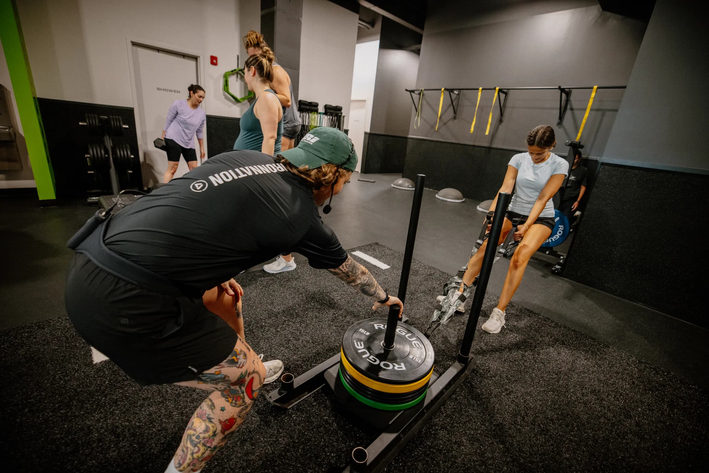 Coach guiding an athlete through a sled row