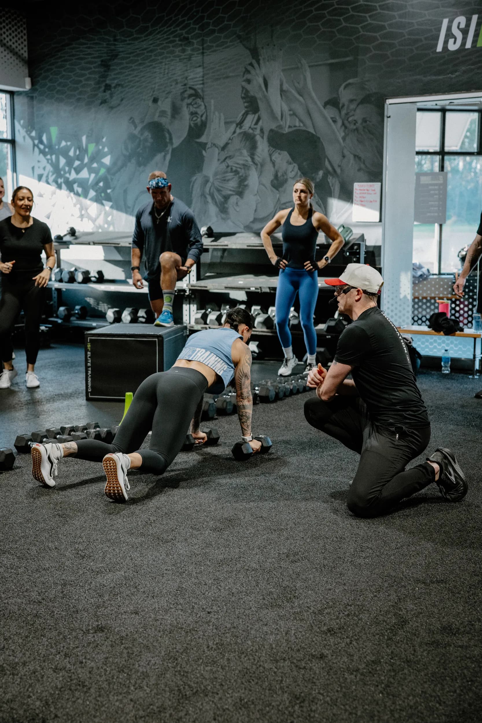 An ISI coach guiding a member through a floor exercise